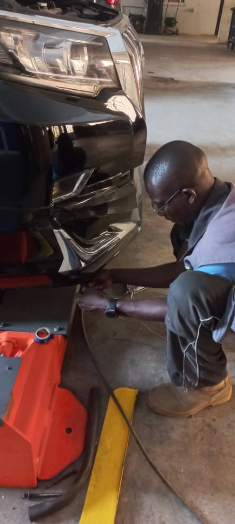 GTGAS technician repairing the front bumper of an SUV